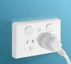 White Zimi Smart Power Point installed on a blue wall with a plugged-in appliance, showcasing smart switch functionality.